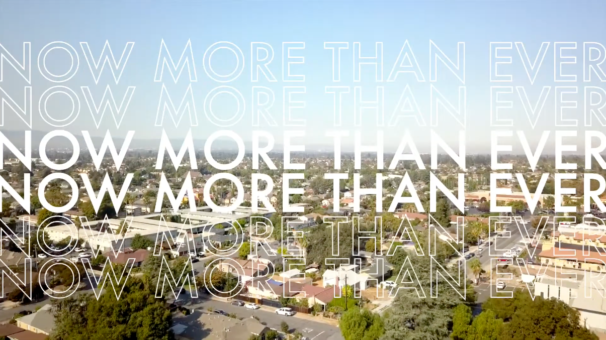 now more than ever overlaid a skyline of a neighborhood